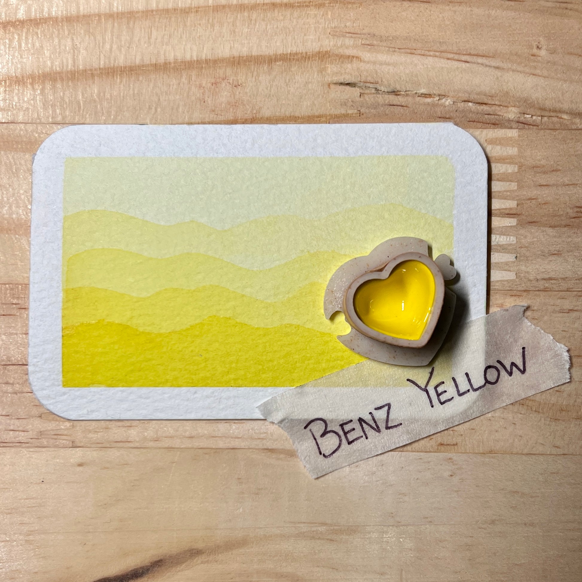 yellow watercolor gradient landscape, heart-shape watercolor pan, labeled 'Benz Yellow', on a wooden surface.