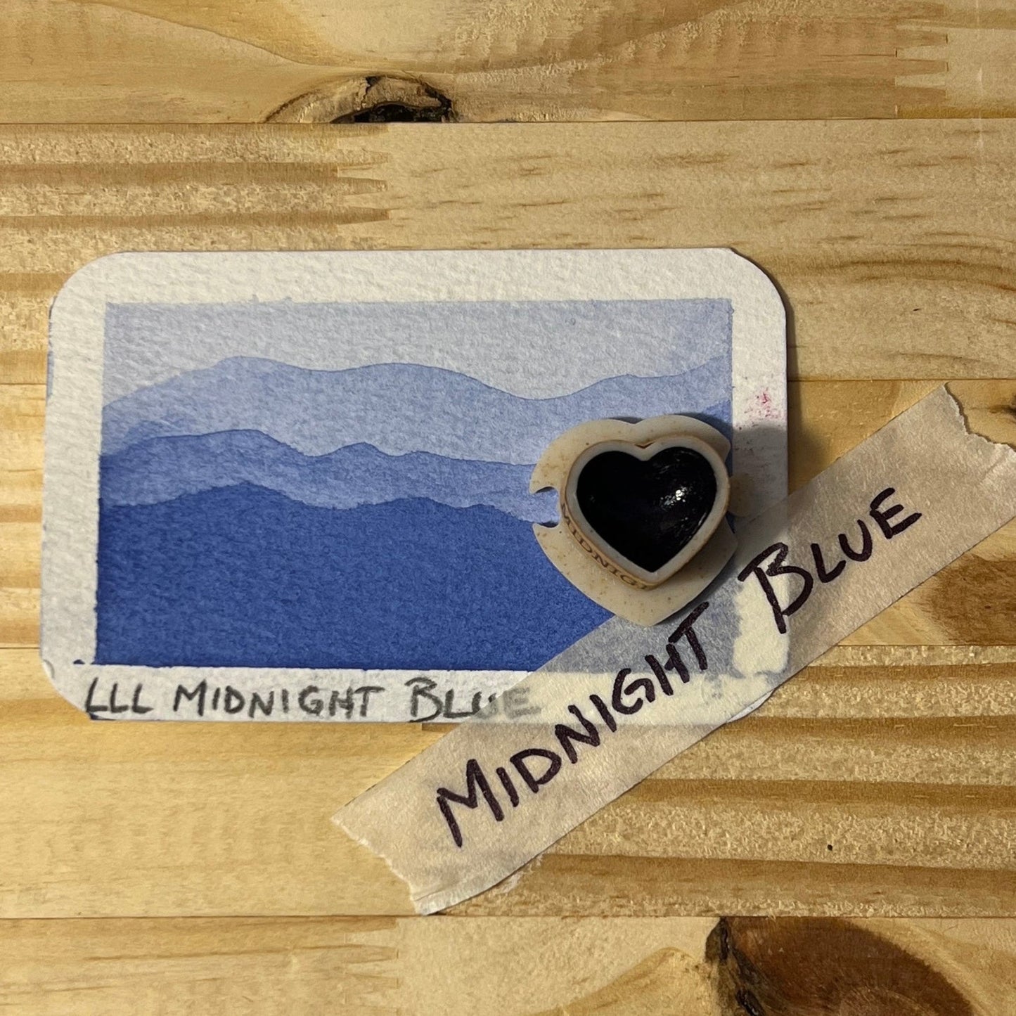 dark blue blue watercolor gradient landscape, heart-shape watercolor pan, labeled 'Midnight Blue', on a wooden surface.