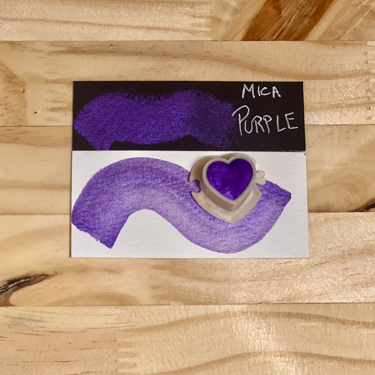 purple mica shimmer watercolor paint  heart shape paint pan with swatch on on a black card with 'mica purple' text and small swatch on white paper