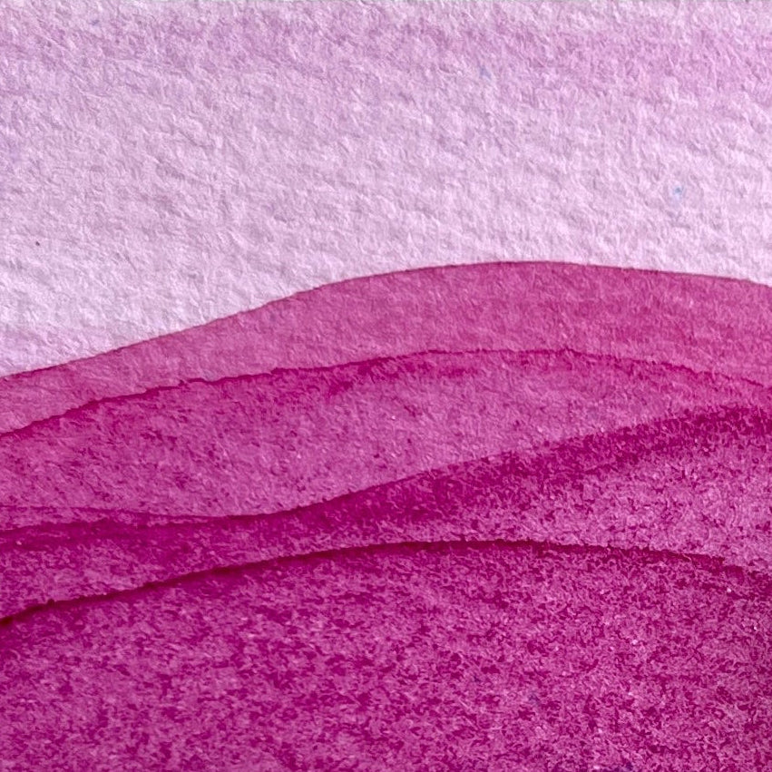 Gradient of magenta watercolor shades on a textured watercolor paper