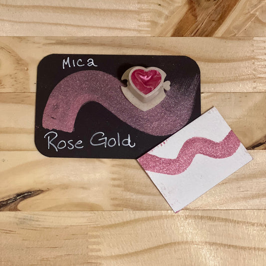 Rose gold mica shimmer watercolor paint  heart shape paint pan with swatch on on a black card with 'Mica Rose Gold' text and small swatch on white paper